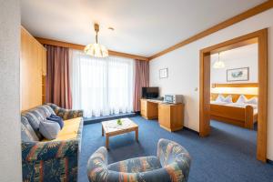 a hotel room with a couch and a bed at Frühstückspension-Appartementhaus Wasserer in Bad Kleinkirchheim