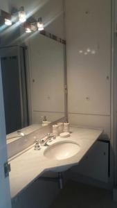 baño con lavabo y espejo grande en EDIFICIO SANTOS DUMONT, en Punta del Este