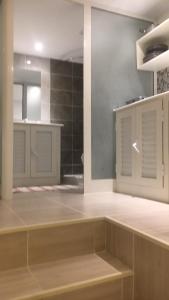 a large kitchen with white cabinets and a mirror at Nid Douillet pour 2 in Sfax