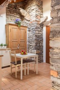 einen Tisch und Stühle in einer Küche mit einer Steinmauer in der Unterkunft T-Rooftop in Como
