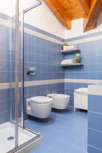 ein blau gefliestes Bad mit einem WC und einer Badewanne in der Unterkunft T-Rooftop in Como
