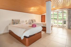 een slaapkamer met twee bedden en een groot raam bij Apartment lucy in Arco da Calheta