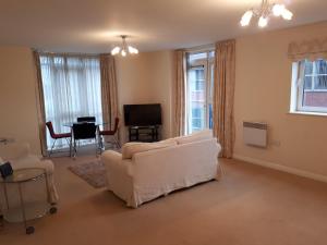 a living room with a white couch and a table at Solihull centre apartments in Solihull