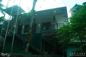 a glass building with a tree in front of it at Eco Villa - Sinharaja in Deniyaya