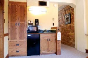 a kitchen with a black refrigerator and wooden cabinets at The Branch House in Deadwood