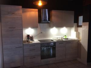 a kitchen with white cabinets and a stove top oven at Appartement Orion in Colmar