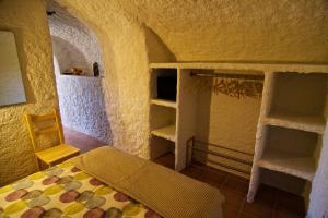 een slaapkamer met een bed en planken in een kamer bij Cueva Pura Vida in Pulpite