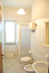 a bathroom with a toilet and a sink and a window at Appartamenti Garden in Capo Vaticano