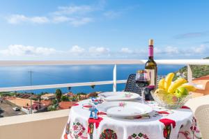 een tafel met een bord eten en een fles wijn bij Apartment lucy in Arco da Calheta