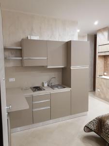 a small kitchen with white cabinets and a sink at Le Cale' B&B in San Severo +25 photos