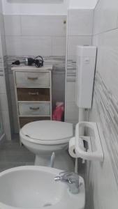 La salle de bains est pourvue de toilettes blanches et d'un lavabo. dans l'établissement Apartments on promenade, à Trappeto