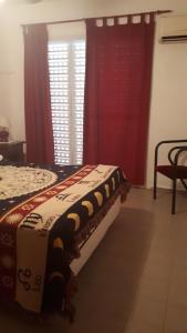 1 dormitorio con 1 cama con cortinas rojas y ventana en Casa con Piscina in 