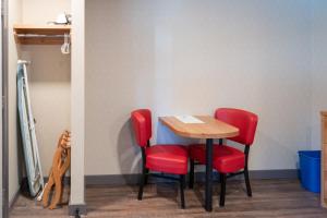 a room with a table, chair and a refrigerator at Banff Rocky Mountain Resort in Banff