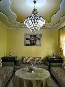 sala de estar con mesa y lámpara de araña en Adam's House- Fes City en Fez