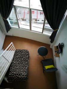 a room with a bed and a chair and a window at Comfort Zone @ The CEO Loft by Joal in George Town