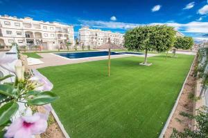 trawnik z basenem przed budynkiem w obiekcie orihuela costa - torrevieja w mieście Orihuela