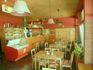 a restaurant with wooden tables and chairs and a bar at Penzion Kaplna in Kaplna