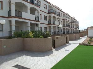 duży budynek apartamentowy z zielonym trawnikiem przed nim w obiekcie orihuela costa - torrevieja w mieście Orihuela