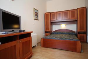 a bedroom with a bed and a flat screen tv at Studio Apartmani Bijeli Delfin in Biograd na Moru