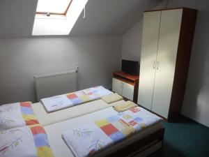 1 dormitorio con 2 camas y armario en Penzion Kaplna, en Kaplna