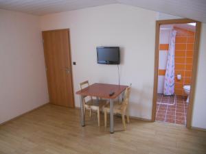 una camera con tavolo, sedie e televisore di Penzion Kaplna a Kaplna