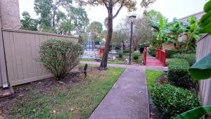 a walkway in a yard next to a fence at Galleria Area Condo, 2 Bedrooms 2 Story - Ocee in Houston