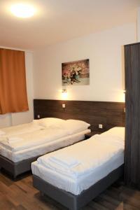 2 łóżka pojedyncze w pokoju hotelowym z: w obiekcie Pionier Hotel Hamburg Wandsbek w mieście Hamburg