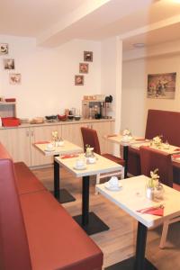 a restaurant with tables and chairs and a kitchen at Pionier Hotel Hamburg Wandsbek in Hamburg