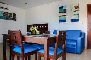 a dining room with a table and blue chairs at Playa Linda Hotel in Progreso