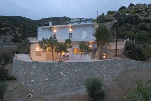 a house on a hill with a stone wall at Skouros Villa in Kastrí