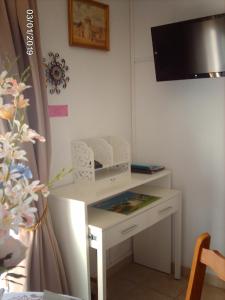 a white desk with a television on a wall at Appartement Locéanaïs in Régusse