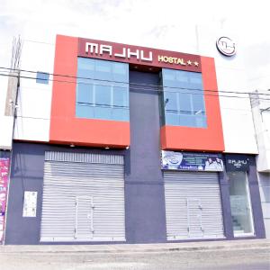 un edificio con dos puertas de garaje delante de él en Majhu Hostal en Tacna