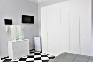 1 dormitorio con armarios blancos y suelo a cuadros en blanco y negro en Il cortiletto en Ravanusa
