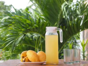 una botella de zumo de naranja junto a un plato de naranjas en panglao moravian apartments, en Panglao