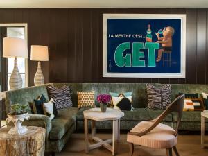 a living room with a green couch and a table at Hotel 850 SVB West Hollywood at Beverly Hills in Los Angeles