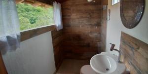a bathroom with a toilet and a sink and a window at Suite da Fernanda in Vila Velha