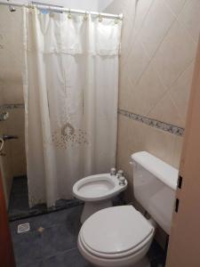 ein Badezimmer mit Toilette und Duschvorhang in der Unterkunft Casa en Playa Perelli in Villa Carlos Paz