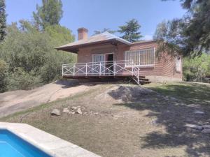 una casa in mattoni con una piscina di fronte di Casa en Playa Perelli a Villa Carlos Paz