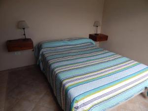 un letto in una camera da letto con due comodini e due lampade di Casa en Playa Perelli a Villa Carlos Paz
