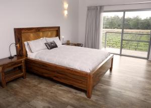a bedroom with a large bed and a large window at Lot113 Vineyard Accommodation in Upper Swan