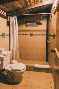 a bathroom with a toilet and a shower at Cuna Luna Hosteria in Olón