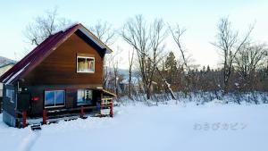 a small cabin in the snow in a field at Lucky Duck Cabin in Akakura