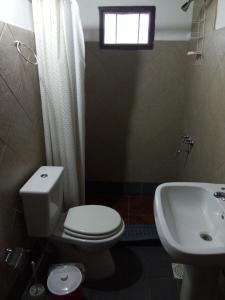 baño con aseo y lavabo y ventana en Mi Refugio en Río Gallegos