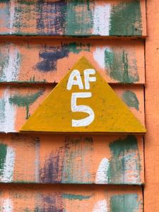 a yellow sign on the side of a building at Beach Shack Chalet - Garden View Aframe Big Unit in Tioman Island