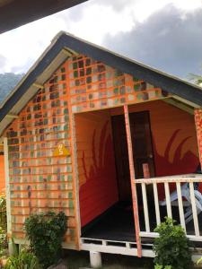 a brick house with a porch and a balcony at Beach Shack Chalet - Garden View Aframe Big Unit in Tioman Island