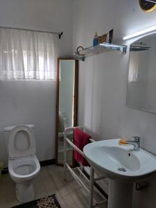 a bathroom with a toilet and a sink at Florence Cottage in Beddegama