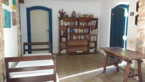 um quarto com uma mesa e uma estante de livros com livros em Casas dos Sonhos em Paraty