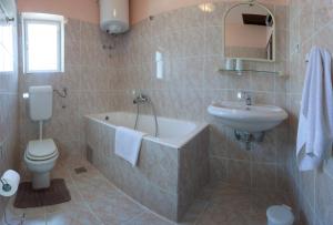 a bathroom with a tub and a toilet and a sink at Apartments Beautiful Sandy Beach in Split