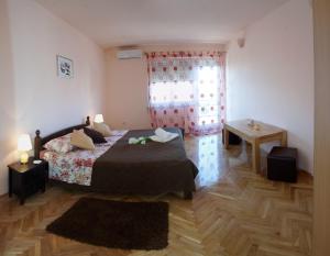a bedroom with a bed and a window at Apartments Beautiful Sandy Beach in Split