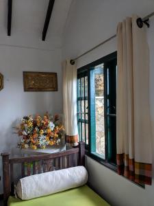 a room with a bed and a window with flowers at Florence Cottage in Beddegama